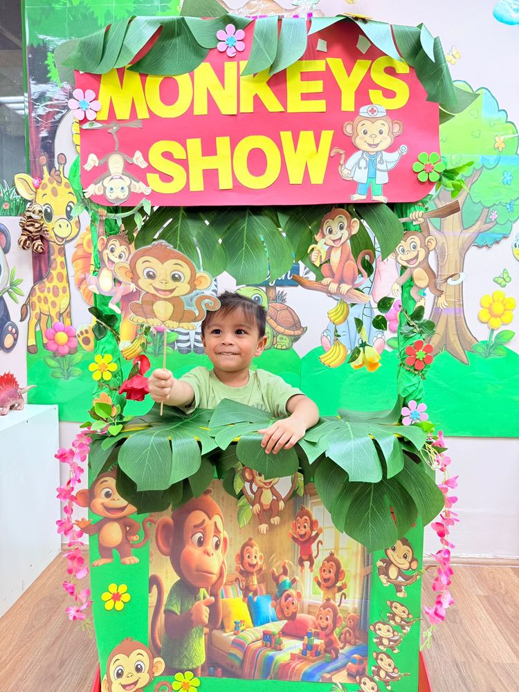 A toddler peeking out of the Monkeys Show jungle stage